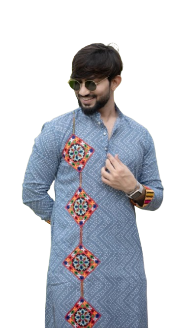 Man wearing sunglasses and a blue patterned kurta with colorful decorative patches outdoors.